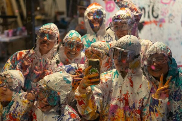 Kuvituskuva: Ryhmä nuoria ihmisiä sotkeutuneena yltä päältä maaliin.