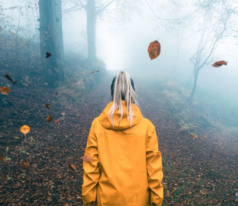 Kuvituskuva: keltaiseen sadetakkiin pukeutunut tyttö syksyisessä metsässä.